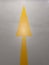 Yellow forward arrow sign on grey asphalt road