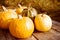 Yellow fresh pumpkins in bright sunlight on an old wooden surface. Autumn harvest of pumpkins.