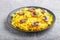 Yellow fried rice with champignons mushrooms, turmeric and oregano on blue ceramic plate on a gray concrete background. side view