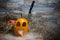 Yellow and funny halloween pumpkin with a knife in his head and smoke or steam from his mouth. Stands on a wooden stand against a