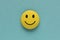 Yellow funny smiley face on blue background. Positive mood concept