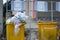 yellow Garbage Trash Bin full of garbage in small village