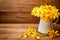 Yellow gardenia flower in vase on wooden background