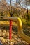 Yellow gas pipe on red supports in autumn park