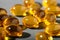 Yellow gelatin capsules on a gray background. Food supplement, vitamin D, omega, vitamin C, multivitamins.