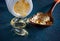 Yellow gelatin capsules with a small drug Omega-3, in a wooden spoon, on a dark blue textured background