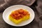 Yellow Gelatinous rice with shrimp topping on white plate