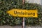 Yellow German arrow road sign pointing to left saying `route diversion`