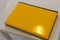 Yellow glossy laptop on a white wooden table