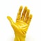 Yellow glove is shown on an arm. The hand wearing glove has its fingers spread apart and is holding something in front
