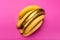 Yellow and golden bananas isolated on pink, ripe bananas