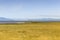 Yellow grass at low tide and iron cross on Panet Rock in Lâ€™Islet-sur-Mer with lâ€™ÃŽle-aux-Oies and Charlevoix in the background