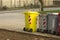 Yellow and gray trash bins with wheels