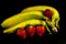The yellow and green banana`s and four red fresh sweet strawberrys