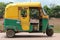 Yellow and green indian auto rickshaw. Yellow and green tuktuk near river