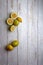 yellow and green lemons, cut and uncut on a light white background of deteriorated wood