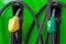 Yellow and green petrol gas pump nozzles in a service station