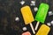 Yellow, green and pink popsicles.Top view, space for text.