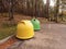 Yellow and green plastic and rubbish collection bins on a car park in a forest park, concept ecology, rubbish segregation