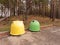 Yellow and green plastic and rubbish collection bins on a car park in a forrest park, concept ecology, rubbish segregation