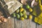 Yellow Green Plums in Brown Craft Paper Bag Scattered on Plank Wood Table Dry Autumn Leaves Knitted Sweater Fall Cozy Atmosphere