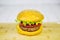 A yellow hamburger with a cutlet, tomato, cucumber and a lettuce leaf on the background of a cutting board. Cooking barbecue