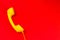 Yellow handset on a red background