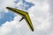 Yellow hang glider wing with cloudy sky on the background
