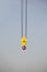 Yellow hanging pulley with cables with a red hook for lifting