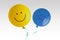 Yellow happy balloon and blue sad balloon flying away on white background - Prevalence of positive over negative mood conept