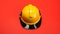 Yellow hard hat isolated on a red background. Safety helmet for workers or firefighters. Generative AI.