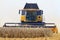Yellow harvester gathers the wheat harvest
