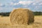 Yellow haystack on wheat field under the beautiful blue cloudy sky