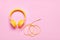 Yellow headphones on pink background. Minimal Music concept, flat lay, copy space