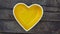 Yellow heart Shaped Porcelain Ceramic Bowl on Wooden Background.