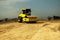 Yellow heavy vibratory roller on asphalt works. Road repair. Highway repair on a sunny summer day. Heavy machinery, forklifts and