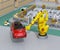 Yellow heavyweight robotic arm carrying red SUV in the assembly factory