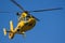 Yellow Helicopter flying in blue sky