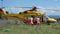 Yellow helicopter rescue operation for patient recovery from assigned ambulance and medical staff equipped for covid 19