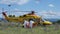 Yellow helicopter rescue operation for patient recovery from assigned ambulance and medical staff equipped for covid 19