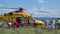 Yellow helicopter rescue operation for patient recovery from assigned ambulance and medical staff equipped for covid 19