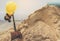 Yellow helmets, gloves and shovel on the sand pile.