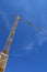 Yellow hoisting crane on blue sky