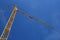 Yellow hoisting crane on blue sky