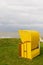 A yellow hooded beach chair at the coast on a dull and overcast day