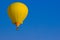 Yellow Hot Air Balloon Against Blue Sky Background