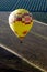 A yellow hot air balloon flies over the Temecula, California.