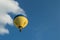 Yellow hot air baloon flying in blue sky