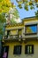 Yellow house in Italy on the roof of which grows the tree. The city of Novara.