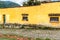 Yellow house & procession carpet in Guatemalan village